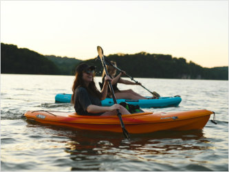 Two people are paddling kayaks on Lake Lure