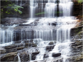 The water is cascading down the rocks at Pearson Falls